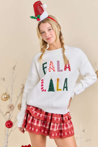 Person wearing a festive sweater with 'FALA LALA' text and plaid skirt on a beige background