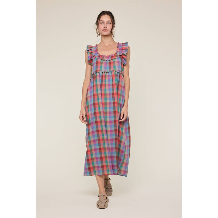 Woman wearing a colorful plaid dress on a beige background