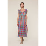 Woman wearing a colorful plaid dress on a beige background