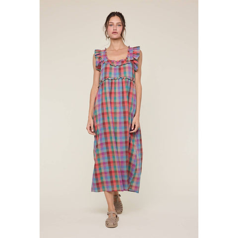 Woman wearing a colorful plaid dress on a beige background