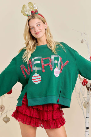 Woman wearing a green 'MERRY' sweater with red ornament details and a red skirt, standing against a neutral background.