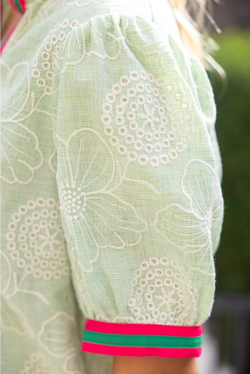 Light green embroidered garment with a close-up of the pattern