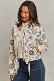 Woman wearing a floral jacket with a plain background
