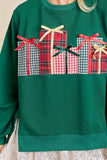 Green sweater with festive gift box design on a neutral background