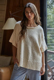 Woman wearing a beige knitted sweater in a home setting
