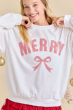 Person wearing a white sweatshirt with 'Merry' and a bow graphic, standing against a neutral background.