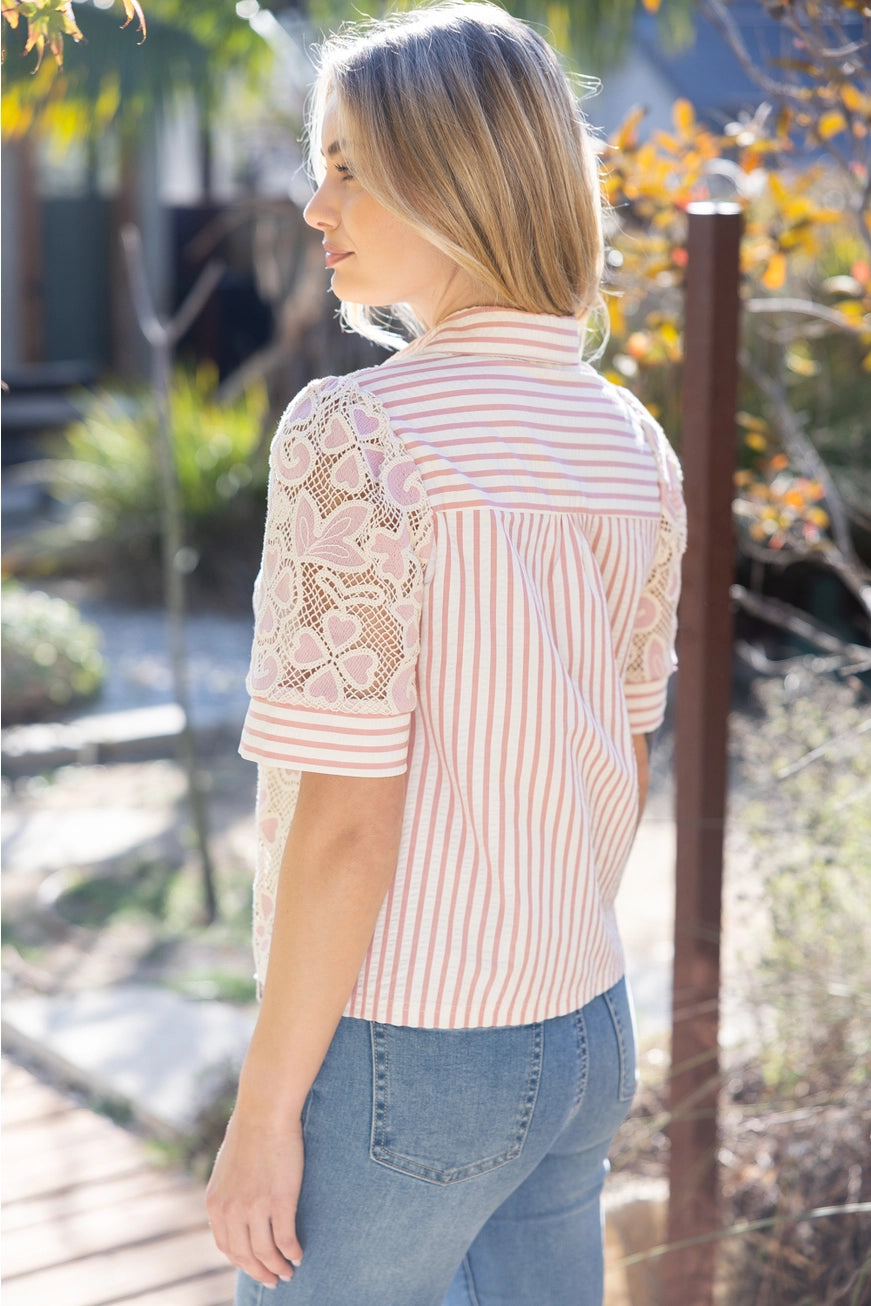 Woman wearing a lace blouse with floral patterns outdoors
