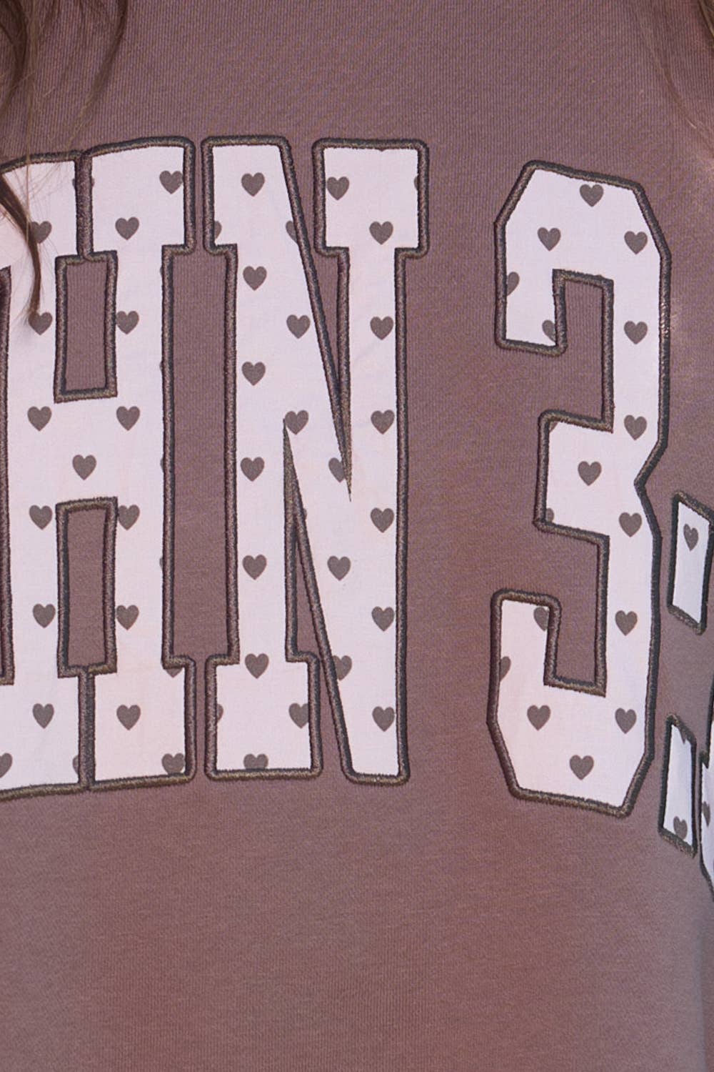 Brown shirt with white text and heart patterns