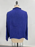 Blue sweater on a mannequin against a white background