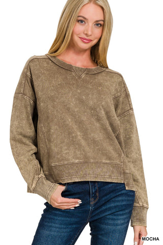 Woman wearing a brown sweatshirt and blue jeans on a white background