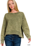 Woman wearing an olive green sweatshirt and blue jeans on a white background