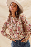 Woman wearing a floral blouse and wide-brimmed hat against a neutral background