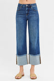 Blue jeans with a cuffed hem on a white background