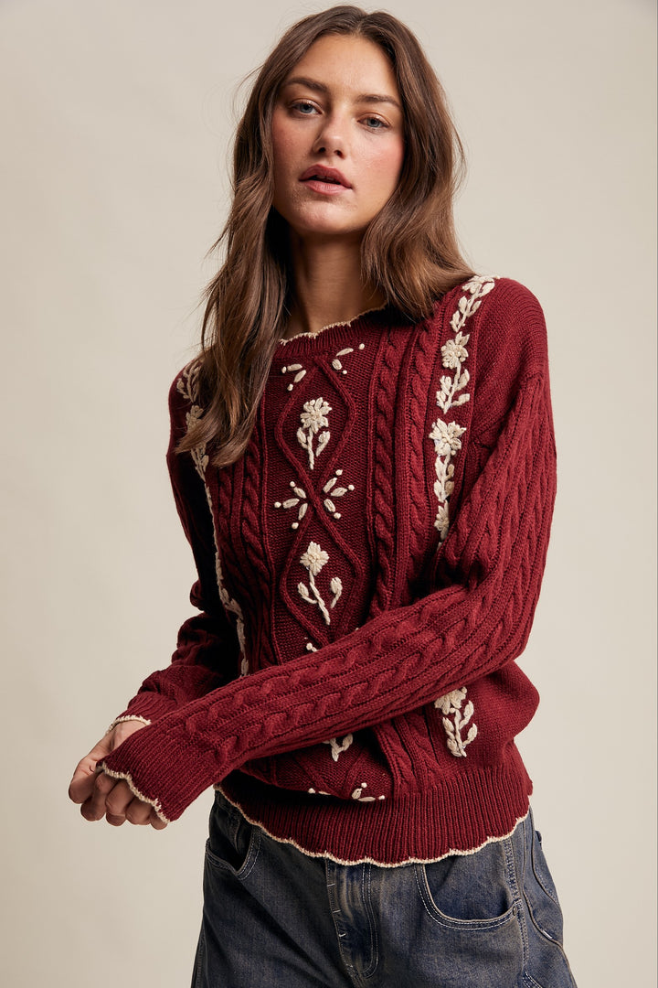 Woman wearing a red sweater with white patterns on a beige background