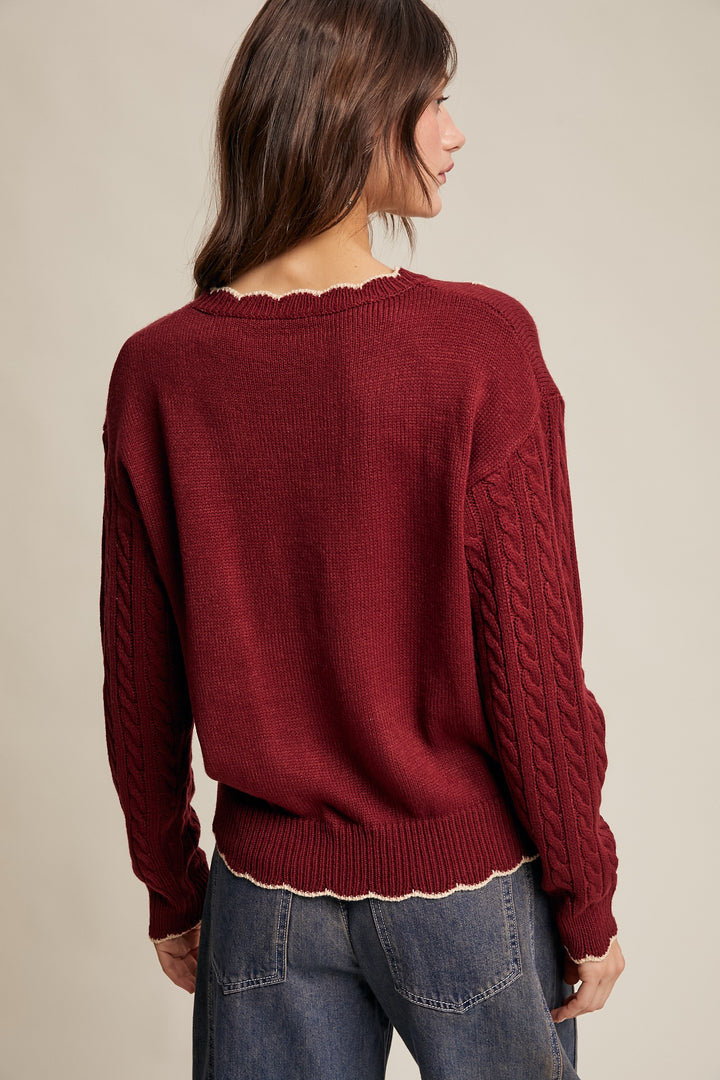 Woman wearing a maroon sweater with a beige background