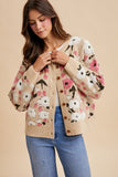 Woman wearing a floral patterned cardigan against a beige background