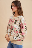 Woman wearing a floral patterned sweater against a beige background