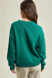 Person wearing a green sweater on a beige background