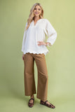 Woman wearing a white blouse and brown pants on a green background