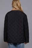 Person wearing a black quilted jacket on a gray background