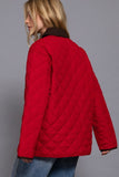 Red quilted jacket worn by a person on a gray background