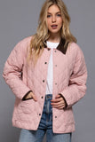 Woman wearing a pink quilted jacket with a gray background