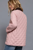 Person wearing a pink quilted jacket on a gray background