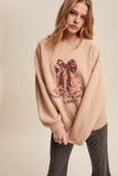 Woman wearing a beige sweater with floral boot design on a beige background