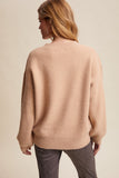 Woman wearing a beige sweater against a beige background