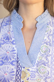 Close-up of a person wearing a patterned garment with floral and geometric designs.