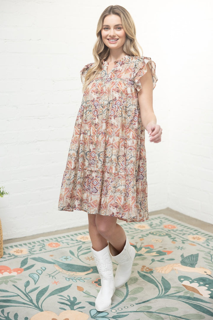 Woman wearing a floral dress standing on a patterned rug.