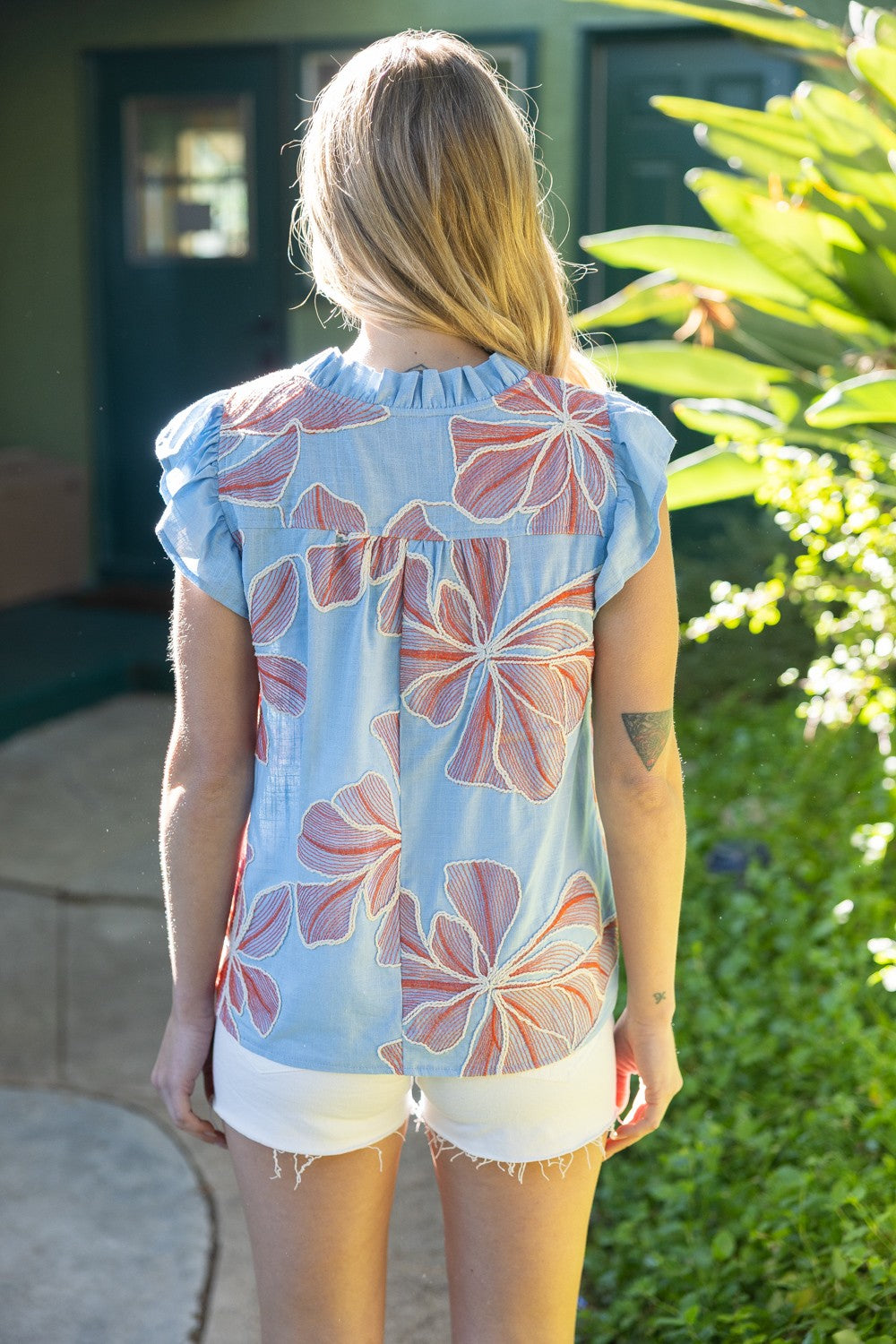 Woman wearing a floral patterned shirt in an outdoor setting