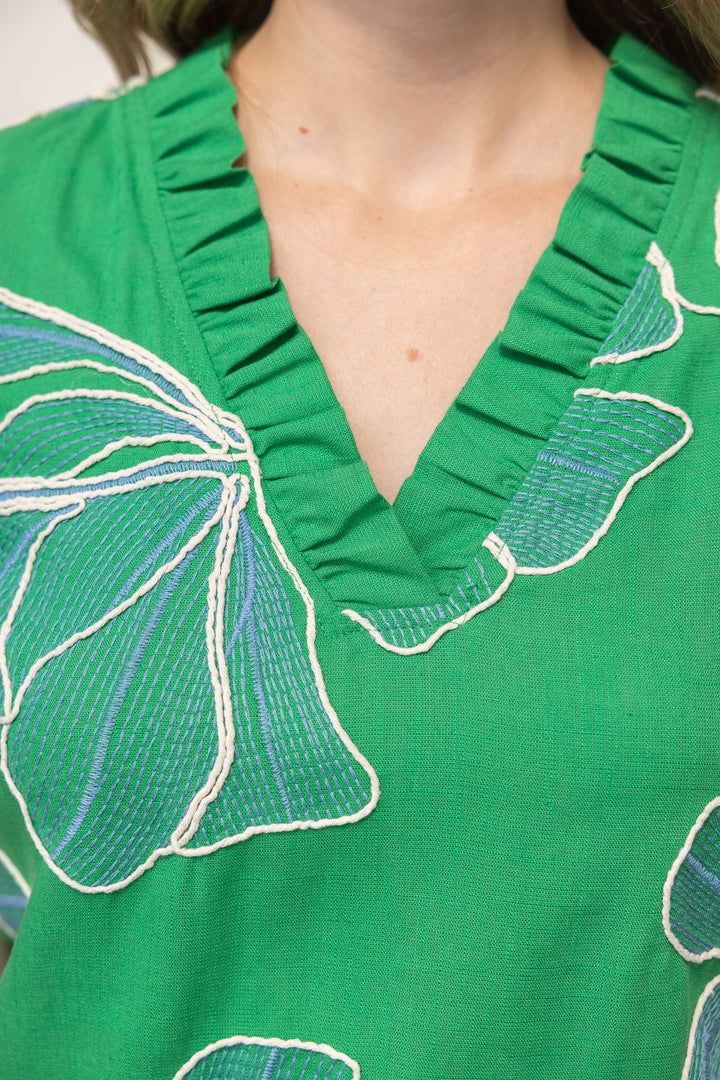 Green dress with butterfly patterns and ruffled neckline