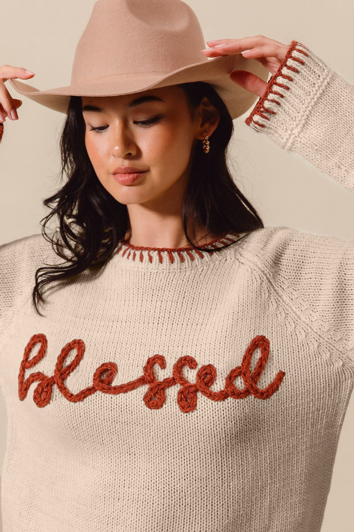 Woman wearing a beige sweater with &