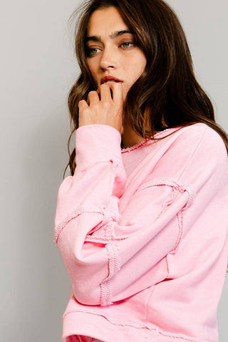 Woman wearing a pink hoodie against a plain background