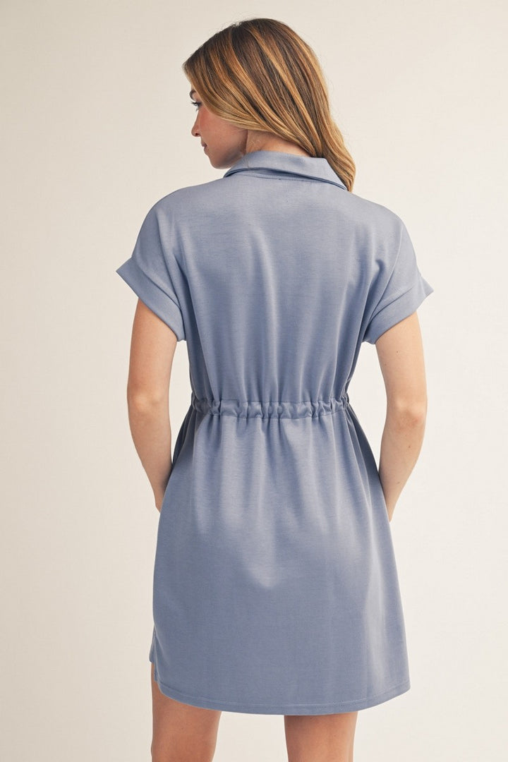 Woman wearing a light blue dress against a beige background