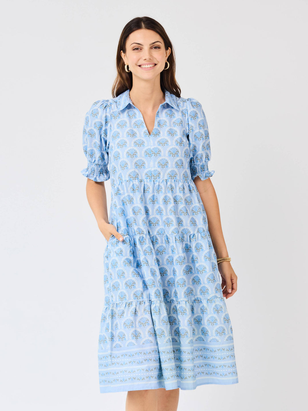 Woman wearing a blue patterned dress on a white background