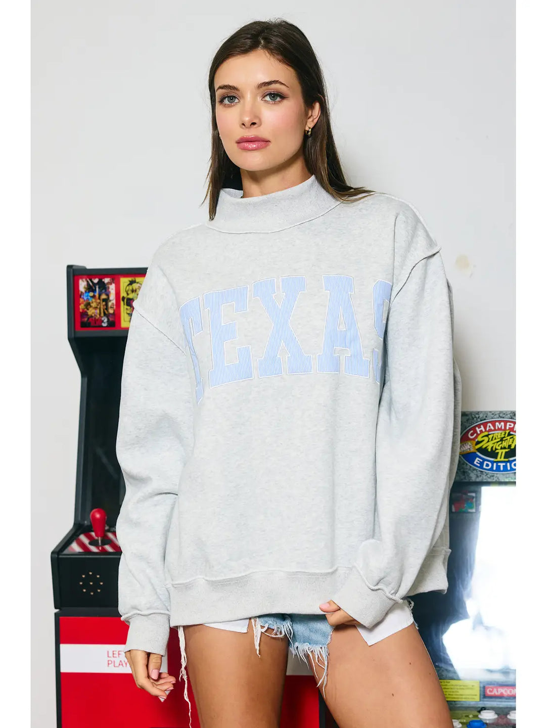 Woman wearing a sweatshirt with Texas appliqued on it. 