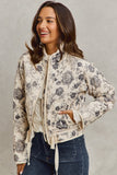 Woman wearing a floral-patterned jacket against a plain background
