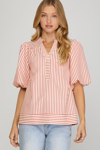 Woman wearing a red and white striped blouse against a gray background