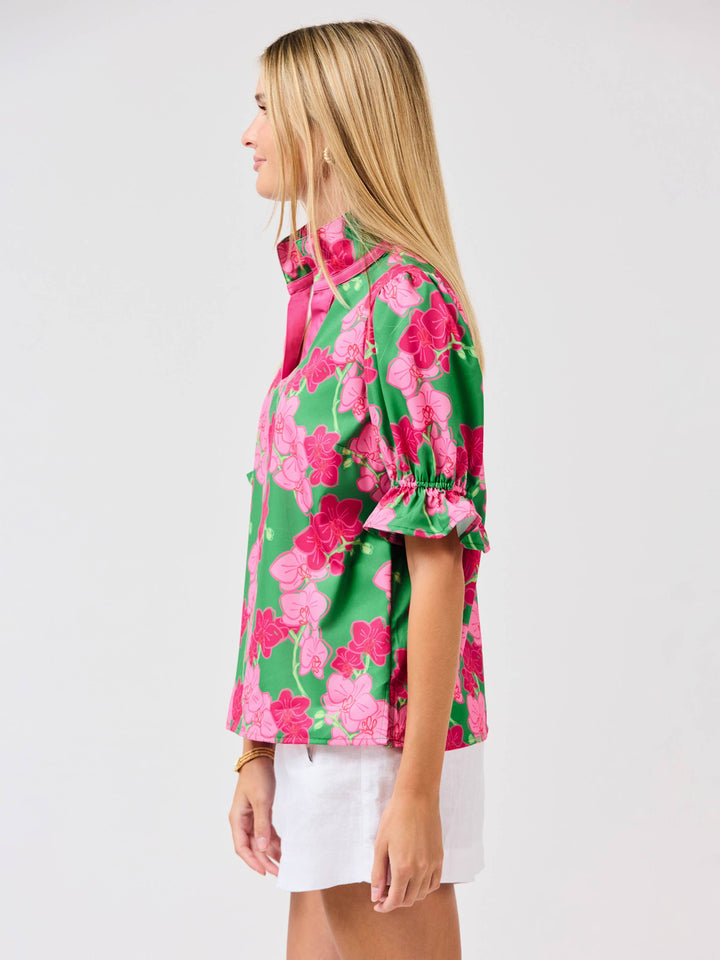 Woman wearing a colorful floral shirt on a white background