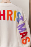 White sweater with colorful letters spelling 'CHRISTMAS' on a plain background