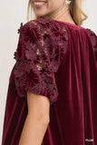 Maroon velvet cape with lace detailing worn by a person, on a plain background.
