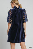 Navy dress with intricate sleeves on a gray background