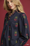 Navy blue dress with colorful floral embroidery on a red background
