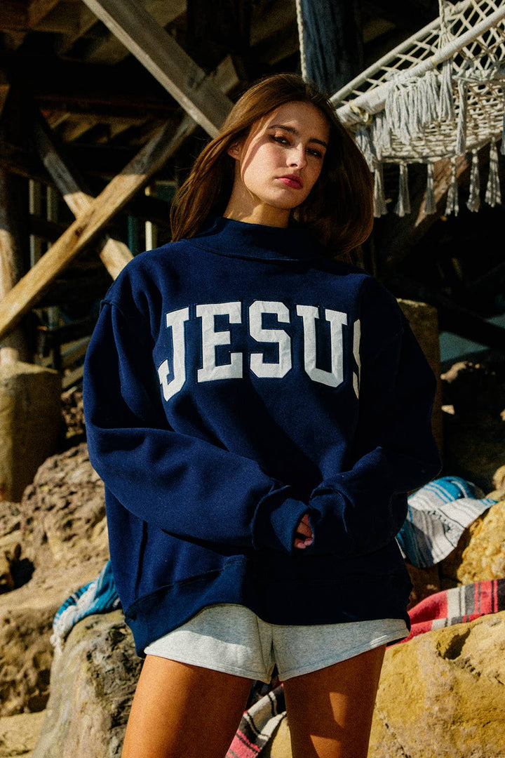 Person wearing a navy blue sweatshirt with &