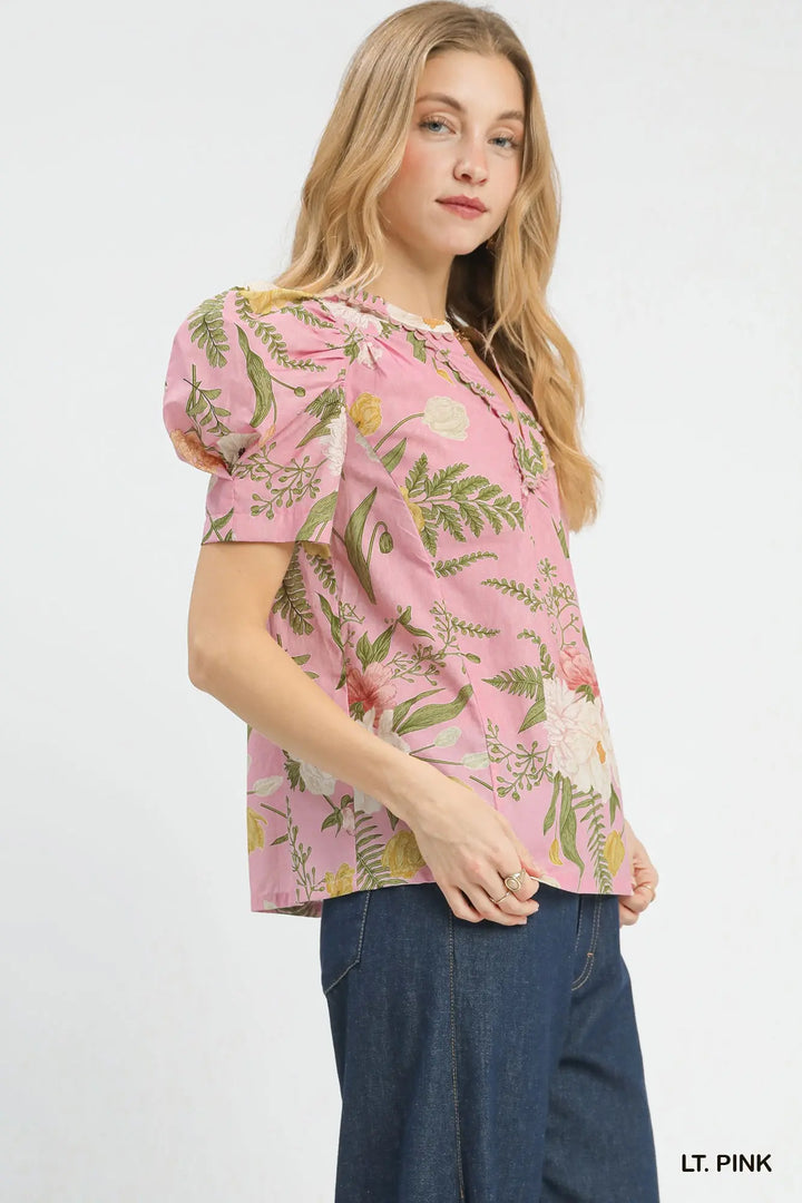Woman wearing a pink floral blouse with blue jeans on a white background
