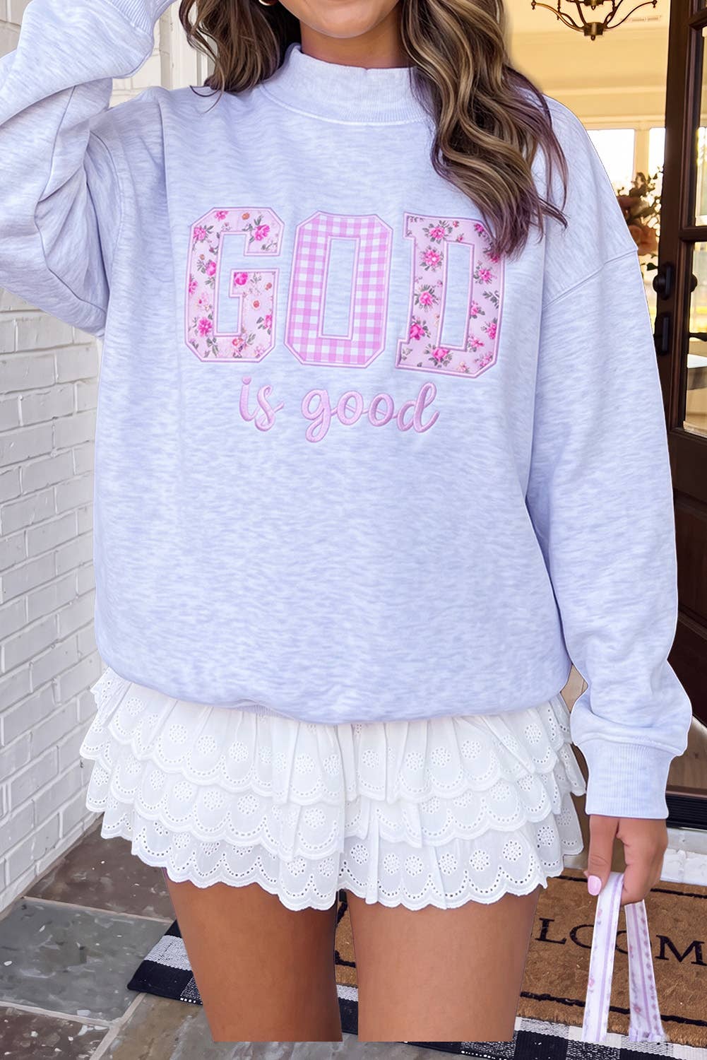 A woman wearing a light heather gray sweatshirt with &