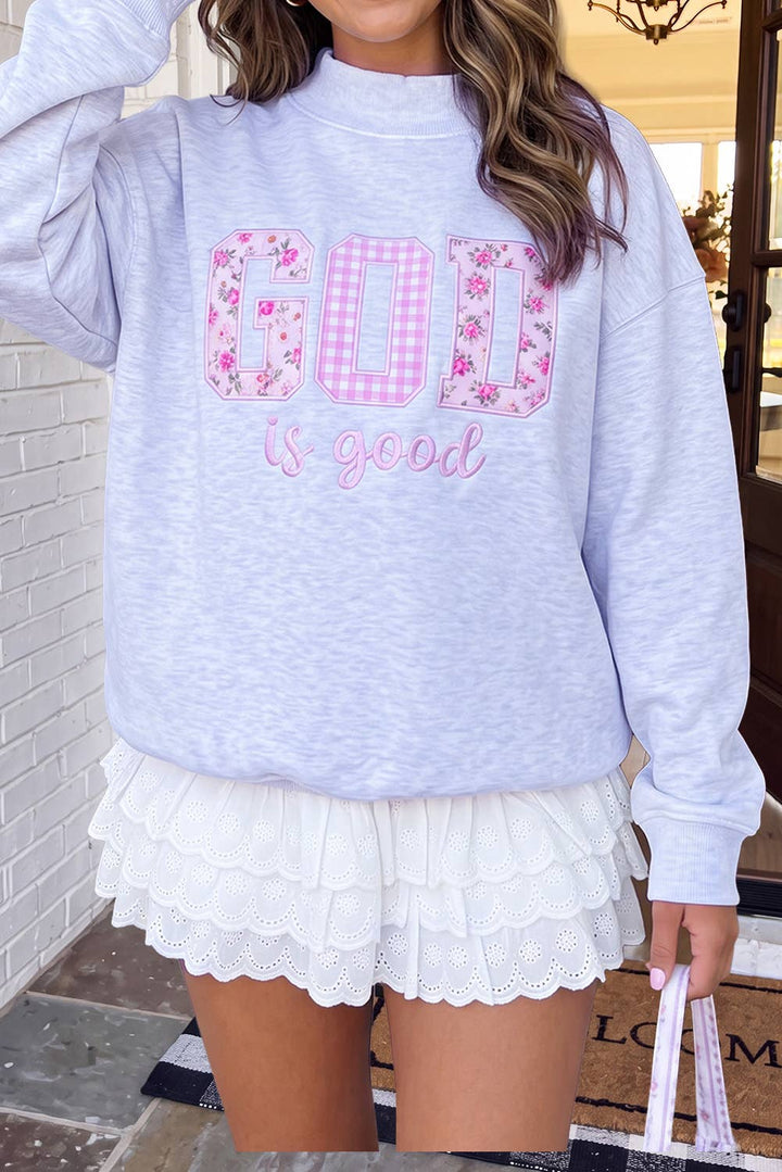 A woman wearing a light heather gray sweatshirt with &