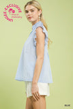 Woman wearing a blue striped sleeveless top with ruffles on a light green background, featuring Umgee branding.